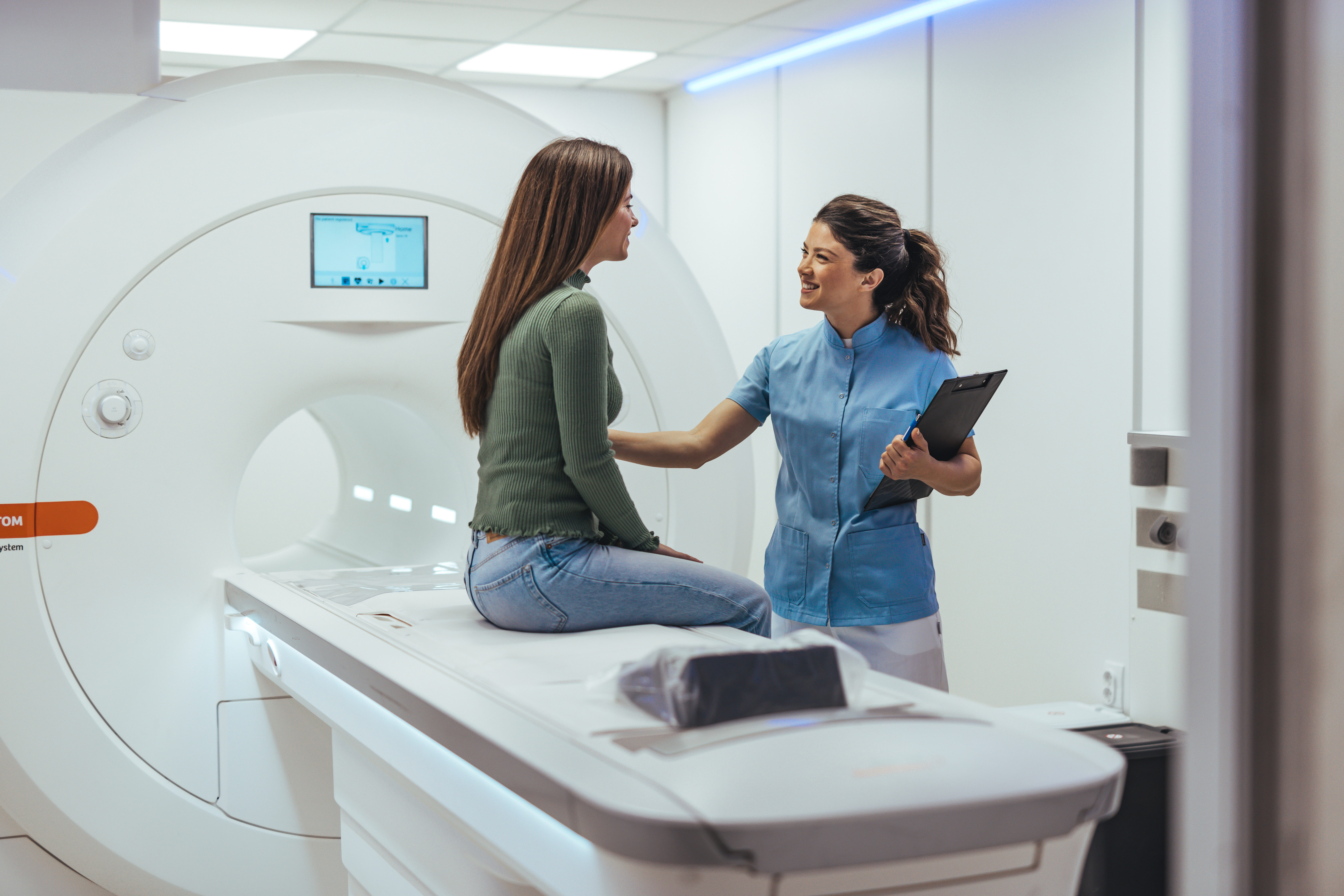 Healthcare Technician Assisting Woman During CT Scan Procedure in Modern Facility Medizinprodukte