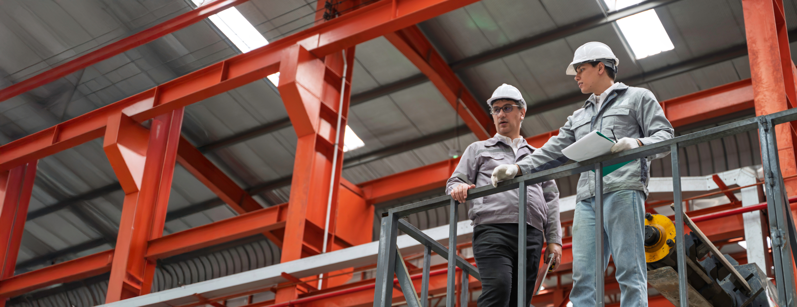 Arbeiter stehen mit Sicherheitsequipment auf einem Gerüst